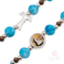 Bracciale Santa Rita Elastico Grani Vetro Celeste e Tau
