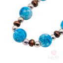Bracciale Santa Rita Elastico Grani Vetro Celeste e Tau